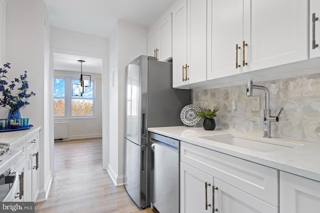 kitchen with tasteful backsplash, stainless steel dishwasher, white cabinets, light stone counters, and sink