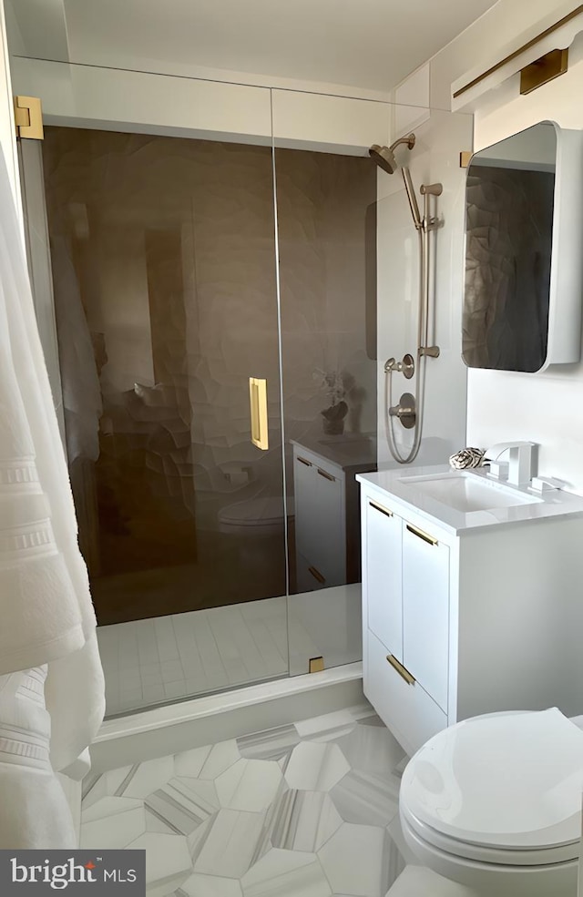 bathroom featuring toilet, tile patterned floors, walk in shower, and vanity