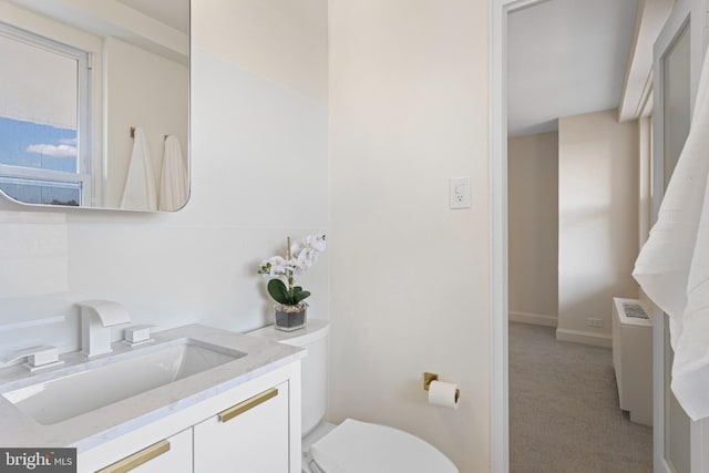 bathroom featuring toilet, vanity, and radiator heating unit