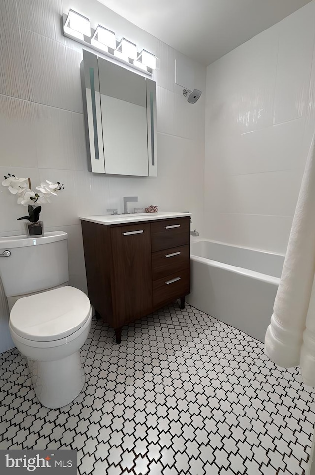 full bathroom featuring toilet, tile walls, washtub / shower combination, and vanity