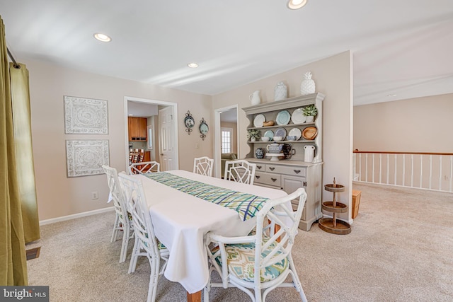 dining space featuring light carpet