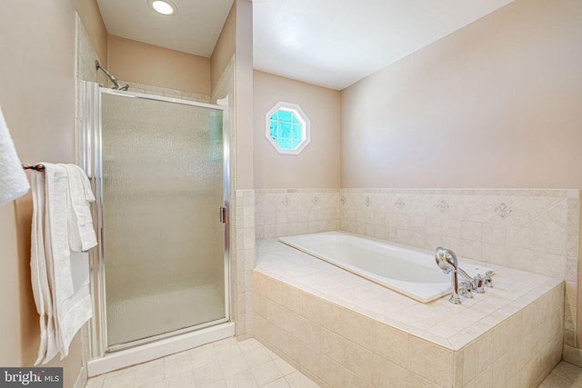 bathroom featuring tile patterned floors and separate shower and tub