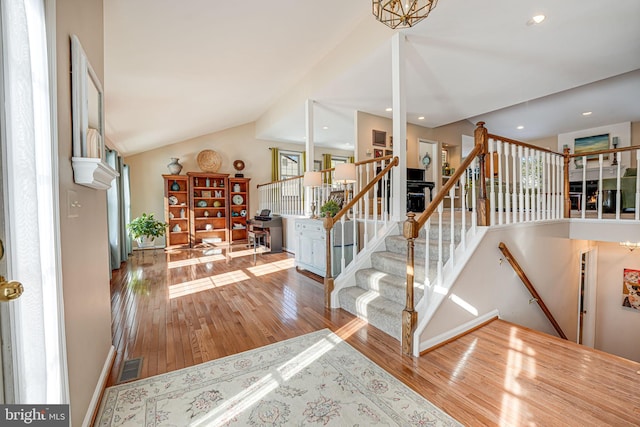 interior space featuring hardwood / wood-style floors, lofted ceiling, and a chandelier