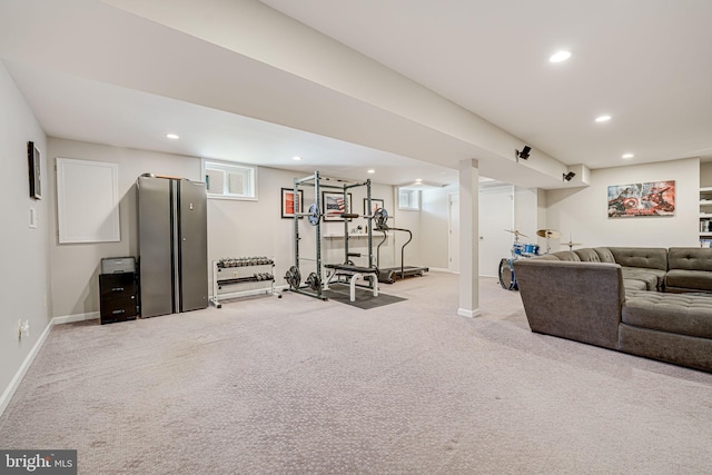 workout room featuring light carpet