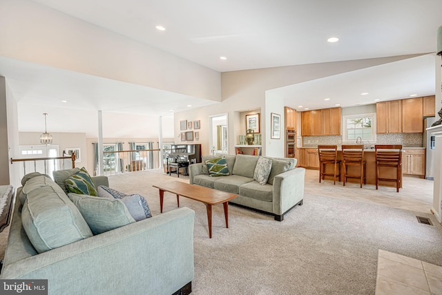 living room featuring lofted ceiling and light carpet