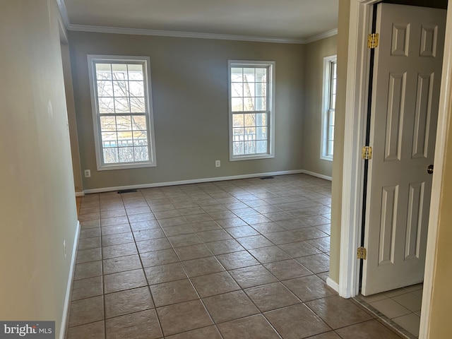 tiled spare room featuring ornamental molding