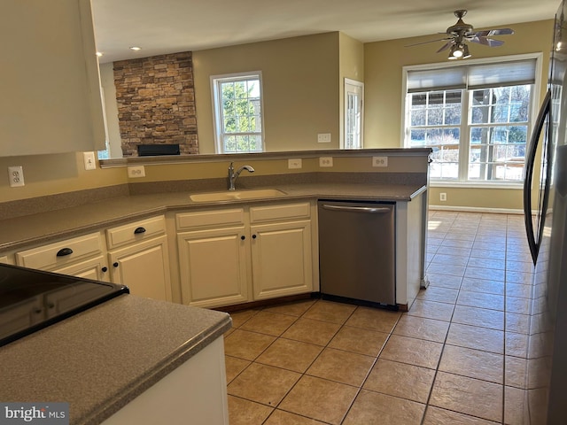 kitchen with sink, white cabinets, stainless steel dishwasher, light tile patterned floors, and ceiling fan