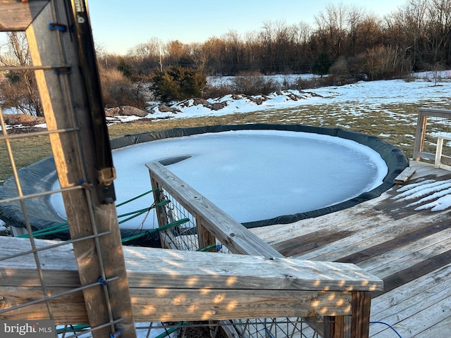 snow covered pool featuring a wooden deck