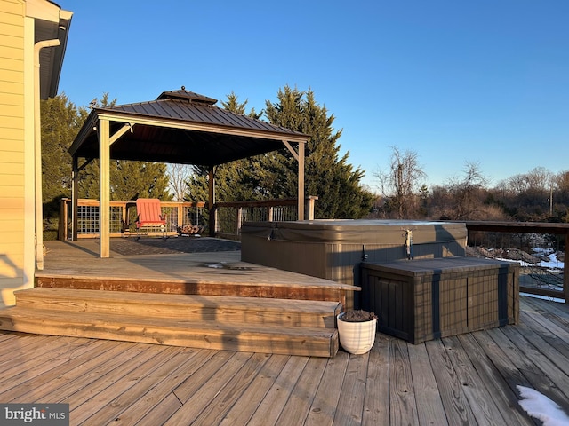 wooden deck featuring a hot tub and a gazebo