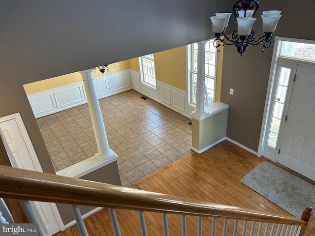 tiled foyer entrance featuring a notable chandelier and ornate columns