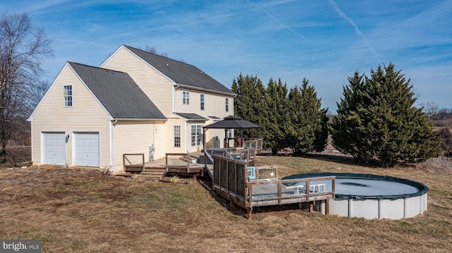 rear view of house featuring a garage, a gazebo, a swimming pool side deck, and a yard