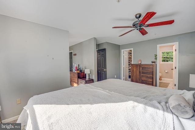 bedroom featuring a spacious closet, connected bathroom, ceiling fan, and a closet