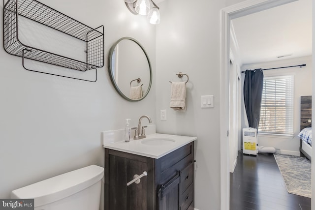 bathroom with hardwood / wood-style flooring, vanity, and toilet