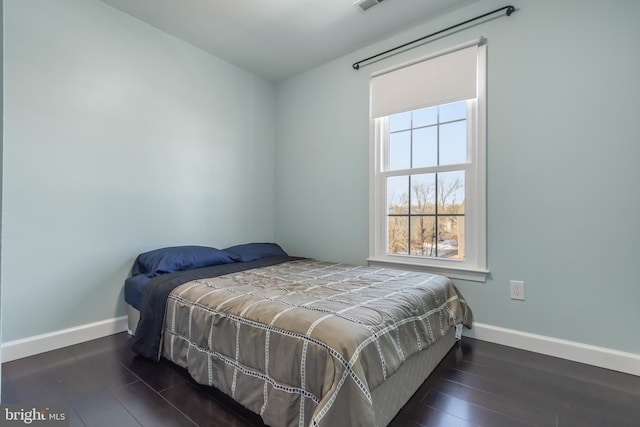 bedroom with dark hardwood / wood-style flooring