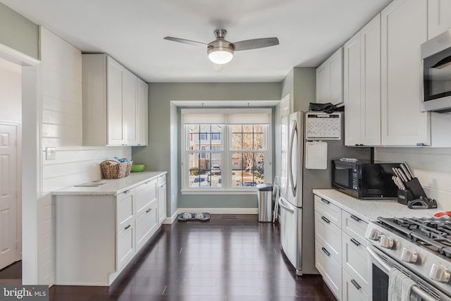 kitchen with white cabinetry, ceiling fan, stainless steel appliances, and dark hardwood / wood-style floors