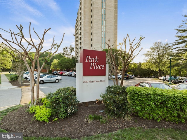 community / neighborhood sign featuring uncovered parking