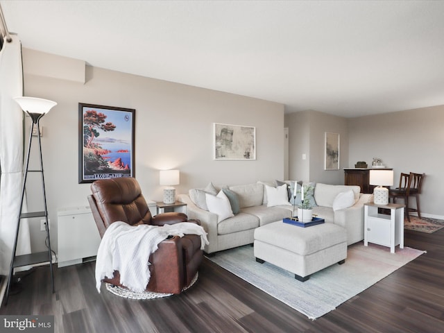 living area with baseboards and dark wood-style flooring