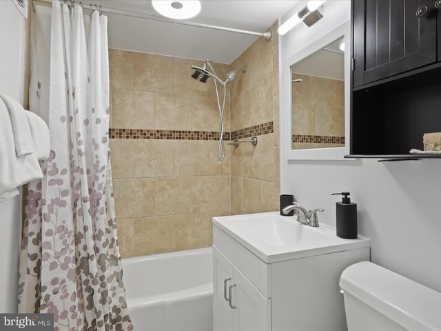 bathroom featuring toilet, shower / bathtub combination with curtain, and vanity