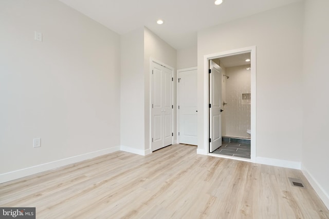 unfurnished bedroom with connected bathroom, recessed lighting, visible vents, baseboards, and light wood-type flooring