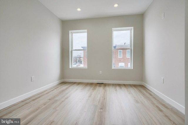 spare room with light wood-type flooring, baseboards, and recessed lighting