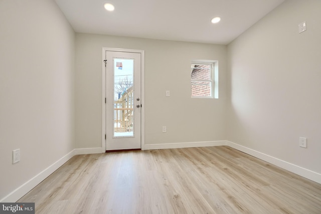 doorway to outside with recessed lighting, light wood-style flooring, and baseboards