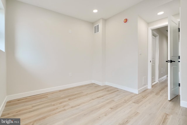 empty room featuring light wood-style flooring, recessed lighting, visible vents, and baseboards