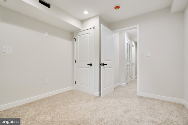 interior space with baseboards, recessed lighting, and light colored carpet