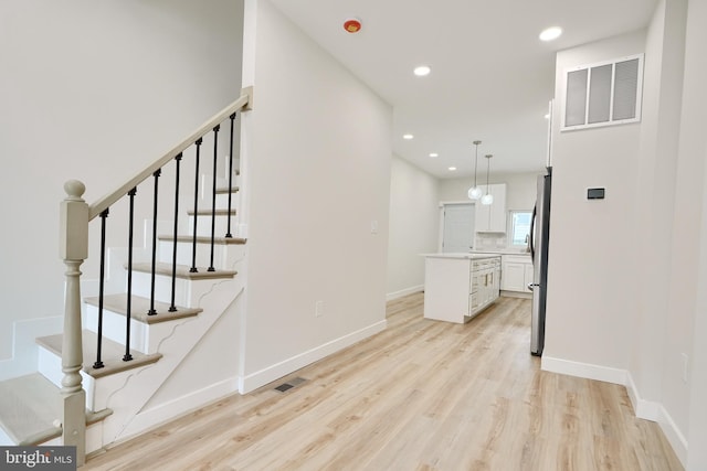 interior space with light wood finished floors, baseboards, visible vents, and recessed lighting