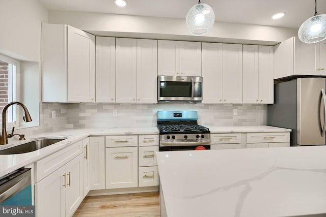 kitchen featuring stainless steel appliances, white cabinetry, and a sink