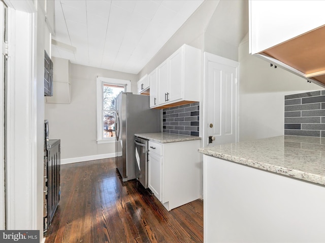 kitchen featuring light stone counters, dark hardwood / wood-style floors, dishwasher, white cabinets, and backsplash