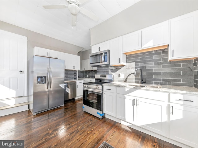 kitchen featuring white cabinetry, backsplash, stainless steel appliances, dark hardwood / wood-style floors, and light stone counters