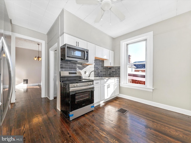 kitchen featuring white cabinetry, decorative backsplash, dark hardwood / wood-style flooring, and stainless steel appliances