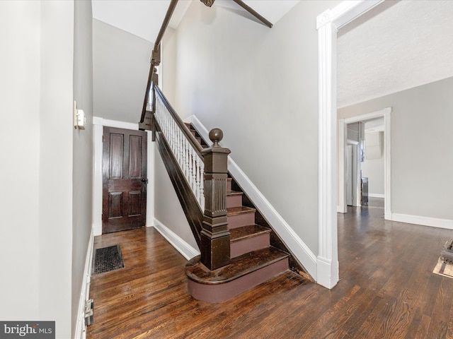 stairs featuring hardwood / wood-style flooring and vaulted ceiling