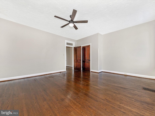 spare room featuring ceiling fan, dark hardwood / wood-style floors, and a textured ceiling