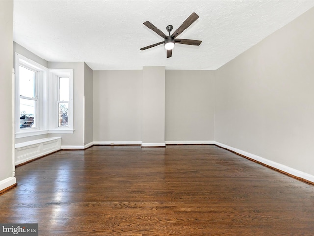 unfurnished room with ceiling fan, dark hardwood / wood-style floors, and a textured ceiling