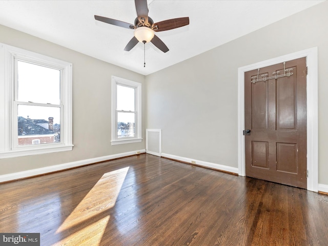 empty room featuring dark hardwood / wood-style flooring and ceiling fan