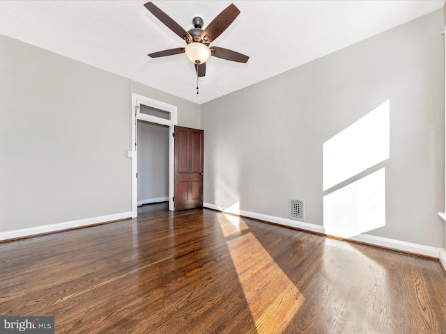 empty room featuring dark hardwood / wood-style flooring and ceiling fan