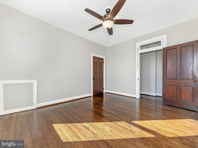 unfurnished bedroom featuring ceiling fan, dark hardwood / wood-style flooring, and a closet