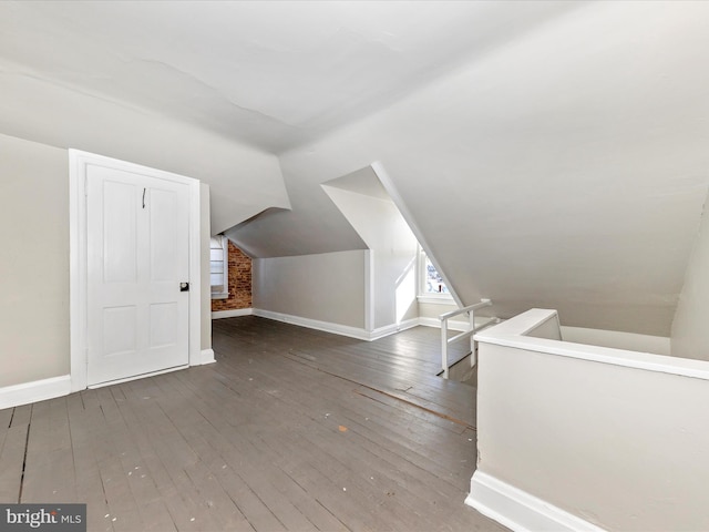 additional living space with dark hardwood / wood-style flooring and vaulted ceiling