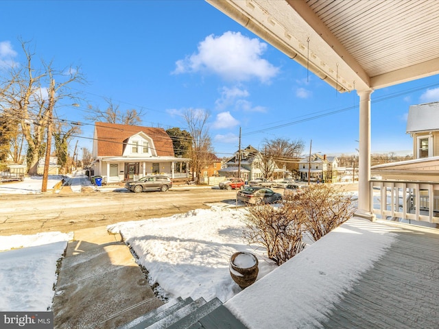 yard covered in snow featuring covered porch