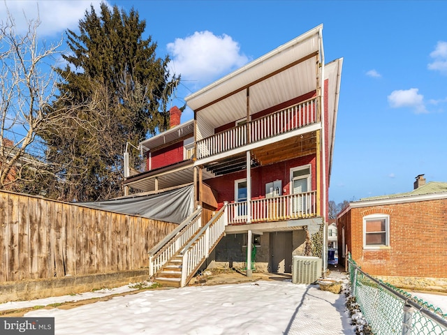 back of property with cooling unit and a balcony