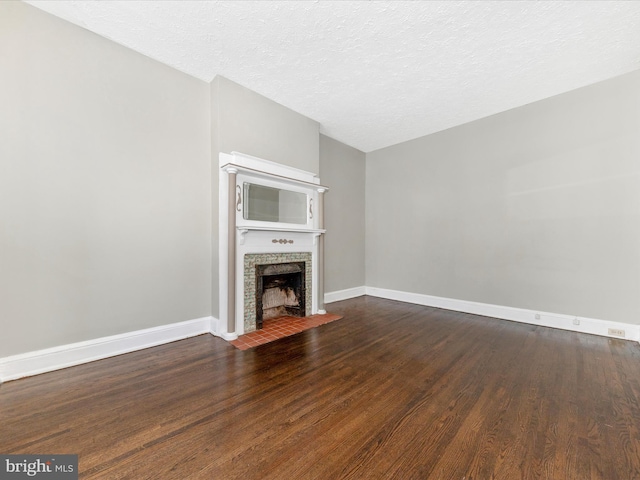 unfurnished living room with dark hardwood / wood-style floors and a textured ceiling