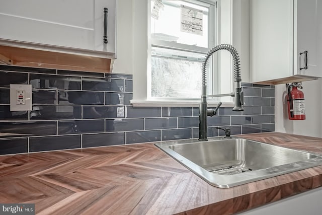 kitchen with white cabinets, sink, and tasteful backsplash