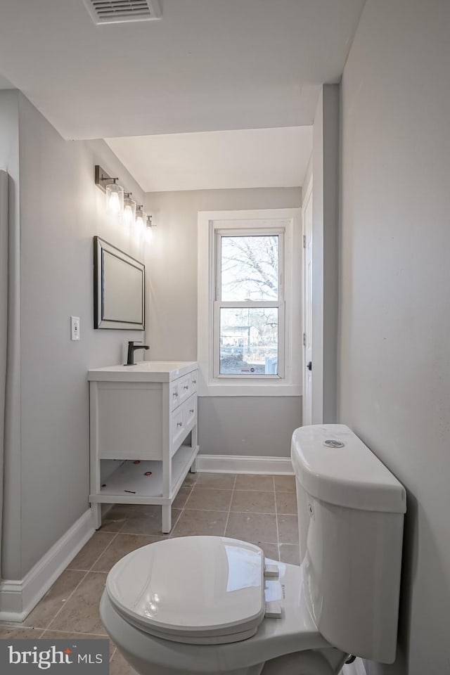 bathroom featuring toilet, tile patterned flooring, and vanity