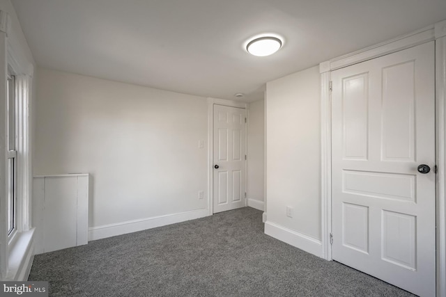 unfurnished bedroom featuring dark carpet