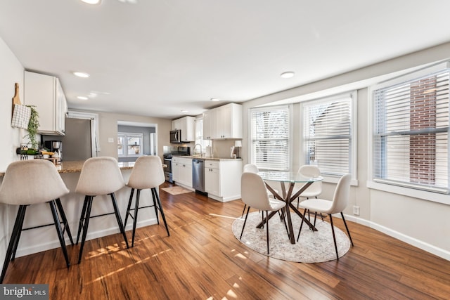 dining area with a healthy amount of sunlight and hardwood / wood-style floors