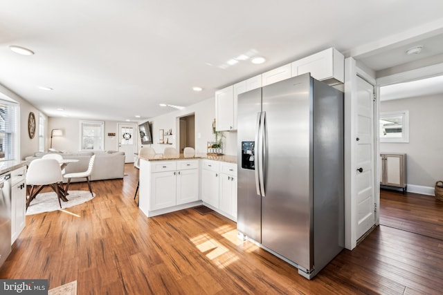 kitchen featuring white cabinetry, wood-type flooring, stainless steel appliances, and kitchen peninsula