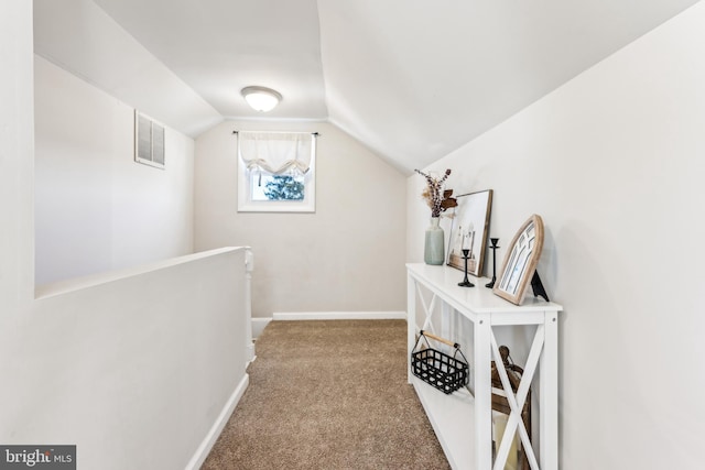 hall featuring carpet floors and vaulted ceiling