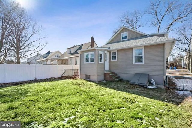 rear view of property with a lawn