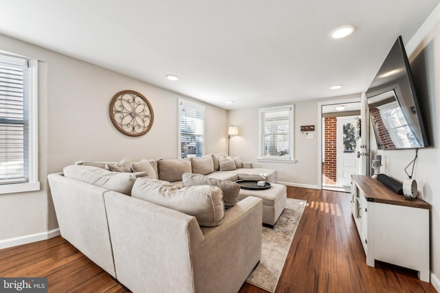 living room with a healthy amount of sunlight and dark hardwood / wood-style flooring